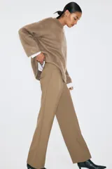 Pantalón sastrero color marrón, de corte recto y tiro medio, con bolsillos laterales y pinzas delanteras.
