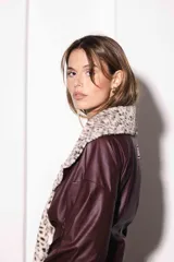 Campera corta de cuerina color bordó con cuello y puños de piel sintética con estampado animal print. Mangas largas abullonadas y corte holgado.