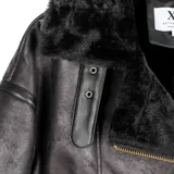 Campera negra de cuero sintético con interior forrado en piel sintética. Tiene cierre frontal y dos bolsillos exteriores abiertos.