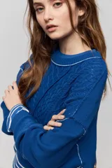 Sweater de tejido tramado color azul con cuello redondo, mangas largas de hombro caído y terminaciones de rib.