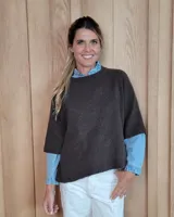 Buzo de punto color marrón chocolate, con diseño holgado, cuello redondo y mangas cortas. Confeccionado en 100% lana lambswool.