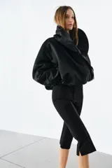 Chaqueta bomber negra ZW Collection con acolchado interior, cuello envolvente de solapa cruzada, mangas largas con puños elásticos y bajo con elástico.