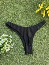 Conjunto de bikini negro con corpiño de un hombro y bombacha colaless.
