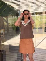 Musculosa marrón de cuero con cuello en V y detalle de caracoles cosidos a mano en el escote y sisas.