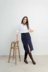 Falda midi de tiro alto confeccionada en pana color azul marino, con cierre frontal de botones y tajo delantero.