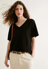 Blusa negra de manga corta con escote en V pronunciado y calce holgado (oversized).