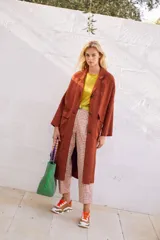 Abrigo oversize color ladrillo, confeccionado en lino pesado, con botonadura simple, bolsillos con solapa y ventilación trasera.