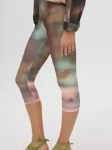 Calza deportiva 3/4 de tiro alto, confeccionada en lycra con un diseño estampado abstracto en tonos tierra, verdes y rosados.