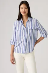 Camisa de manga larga con diseño de rayas verticales en tonos azul y blanco, cuello camisero, cierre frontal y dos bolsillos delanteros con solapa.