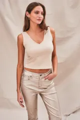 Top ajustado al cuerpo, color arena, de poliéster y elastano.
