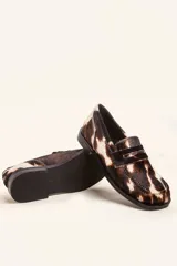 Mocasin de cuero con pelo estampado animal print tipo vaca, con punta cuadrada y suela plana de goma.