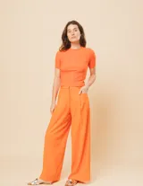 Pantalón de lino color naranja, tiro alto y corte wide leg.