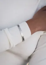 Pulsera esclava abierta de acero quirúrgico con textura martillada.