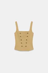 Top corsetero de color tostado con escote cuadrado, tirantes anchos y cierre de cremallera en la espalda. Cuenta con costuras marcadas y filas de botones metálicos dorados decorativos en el frente.