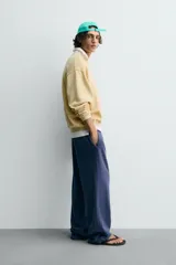 Sudadera de algodón con interior rizo, cuello redondo y manga larga. Presenta un efecto lavado que le da un color amarillo pálido y un estampado frontal en hilo blanco con el texto "west nord 89".