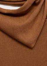 Jersey de punto fino color tostado con cuello asimétrico y adorno de fular incorporado en el cuello. Cuenta con diseño recto y manga larga.
