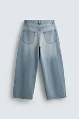 Jeans de denim de algodón, color azul oscuro con efecto lavado. Presentan un corte muy holgado (baggy fit) en toda la pierna y tiro medio. Tienen cinco bolsillos y cierre frontal con cremallera y botón.