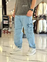 Pantalón cargo de jean azul con múltiples bolsillos en los laterales y diseño holgado.