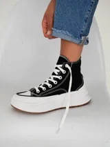 Championes tipo botita de caña alta con diseño bicolor, cuerpo en color negro y suela de plataforma gruesa en color blanco con base de goma.