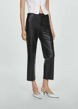Pantalón de corte recto y tiro medio con efecto piel, color negro. Posee trabillas para cinturón, diseño de cinco bolsillos y cierre frontal con cremallera y botón.