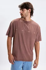 Remera de manga corta con corte oversize, color marrón con efecto lavado. Presenta una estampa frontal con la frase 'true real ones here' en letras pequeñas y tono sobre tono.