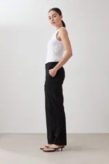 Pantalón de corte recto en color beige, con cintura media y cierre frontal oculto. Presenta un diseño limpio y minimalista con bolsillos laterales.