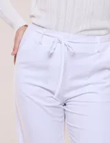 Pantalón de sastre color amarillo claro, de corte recto y largo al tobillo, con cintura ajustable mediante cordón y bolsillos laterales.