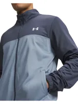 Conjunto deportivo Under Armour compuesto por una campera de cierre frontal con cuello alto en tonos azul marino y celeste, y un pantalón largo en color azul marino con franjas laterales celestes.