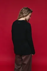 Sweater de tejido de punto negro con tramas de ochos en las mangas y laterales, cuello redondo a la base y mangas largas.