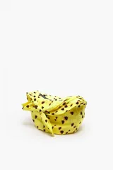 Bolso tipo saca pequeño de tela rosa con lunares negros, cierre de cremallera, asa de hombro con nudo y logo bordado en negro.