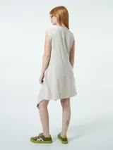 Vestido corto color beige, cruzado, sin mangas y ajustable con lazo lateral.