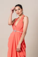 Vestido largo de fiesta color salmón, con cuello halter, corte imperio, falda con movimiento y cinturón blanco fino con hebilla circular.