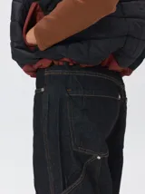 Chaleco de corte cuadrado con diseño bicolor en tonos terracota y crema. Presenta cierre frontal metalizado, parches de nylon en el pecho, interior forrado en corderito y cordón ajustable en el ruedo.