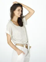 Remera color beige de lino con ribetes de lurex, corte holgado y mangas cortas.