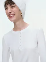 Remera de manga larga confeccionada en tejido acanalado, con escote redondo y cierre frontal con botones. Presenta un ajuste entallado al cuerpo.