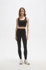Calza deportiva de poliamida, color negro, con diseño al cuerpo y cintura alta.