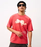 Remera de corte boxy en color rojo, con cuello redondo y mangas cortas. Presenta una estampa frontal con una ilustración fotográfica y la firma Jennie Ruby en tipografía cursiva.