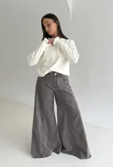 Sweater de punto color marrón chocolate, con cuello redondo y cierre frontal parcial con botones. Presenta mangas largas con puños acampanados y detalle de volados.