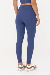 Calza azul de tiro alto, confeccionada en tejido de poliamida y elastano.