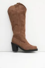 Bota de caña alta color beige, de cuero gamuzado, con taco cuadrado y punta cuadrada.