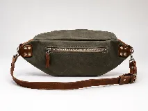 Riñonera de cuero color negro, con múltiples compartimentos con cierre metálico, detalles de tachas en los laterales y correa regulable.