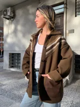 Saco marrón de lana con cuello camisero, cierre con botones y detalle de crochet en los hombros.