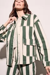 Sobrecamisa oversize con estampado a rayas verticales verdes y blancas, con cuello clásico, cierre frontal con botones y bolsillos de parche en el pecho.