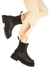 Botas Chelsea negras de cuero vacuno con elásticos laterales, caña media y suela track.