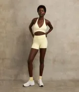 Bermuda corta deportiva marca Get Over, estilo crossfitera, de color amarillo claro, confeccionada en microfibra lisa con diseño sin gancho delantero.