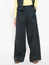 Pantalón de vestir negro con finas rayas verticales blancas, estilo sastrero con pinzas y corte palazzo.