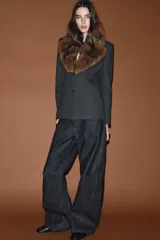 Blazer entallada de color gris oscuro, confeccionada en tejido con algodón. Presenta un cuello solapa con aplicación de pelo sintético desmontable, manga larga, bolsillos delanteros con solapa y cierre frontal con botones.
