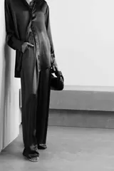 Pantalón negro de seda con puntilla en los laterales y cintura elastizada en la parte trasera.