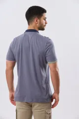 Remera polo de manga corta en color índigo con cuello y botones en contraste. Presenta detalles de color en los puños, aportando un toque sutil y moderno.