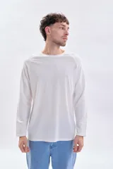 Remera manga larga de color blanco con cuello redondo a la base y mangas tipo raglán con textura acanalada.